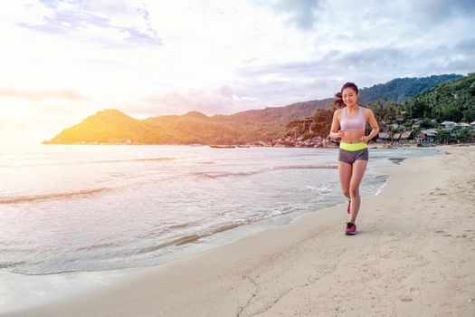 Runner woman running on beach in sunrise