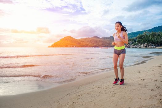 Runner woman running on beach in sunrise