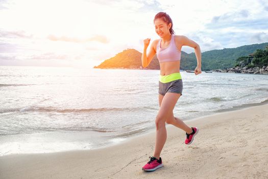 Runner woman running on beach in sunrise