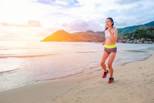 Runner woman running on beach in sunrise