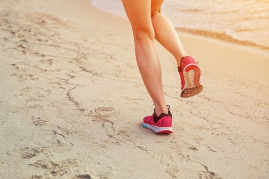 Runner woman running on beach in sunrise