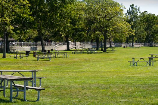 Open picnic tables at a sunny park in Michigan