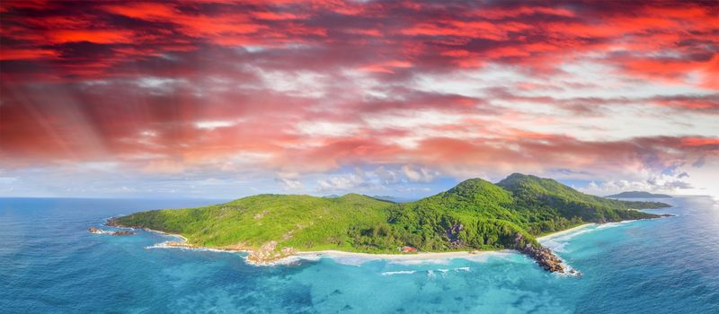 Tropical beach with sea and palm taken from drone. Seychelles famous beach - aerial photo of La Digue Grand Anse.