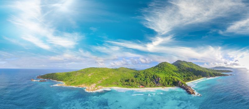 Tropical beach with sea and palm taken from drone. Seychelles famous beach - aerial photo of La Digue Grand Anse.