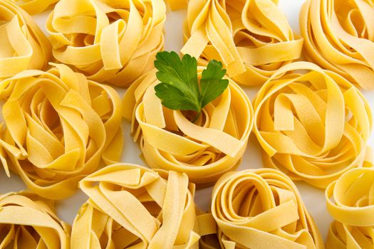 Tagliatelle raw pasta nest egg to dry,
on isolated background