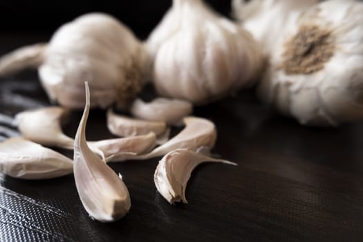 a closeup view of garlic's & cloves on wooden board