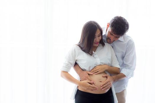 Pregnant Mother and father standing hugging holding belly, family concept.