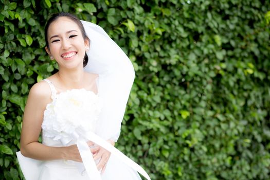 beautiful young woman on wedding day in white dress in the tree wall. Female portrait in the park - Selective focus