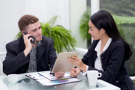 business man and woman people making meeting and looking at tablet for analyzing marketing working at office on desk.