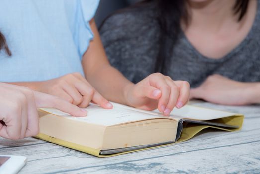 happy family mother and daughter teaching read a book at home.