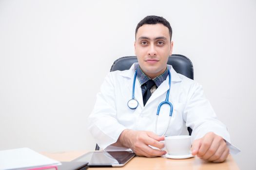 confident male doctor sitting at office desk and relax, medical healthcare concept.