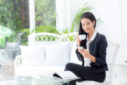 Young businesswoman asian sitting at table in coffee shop and looking phone.