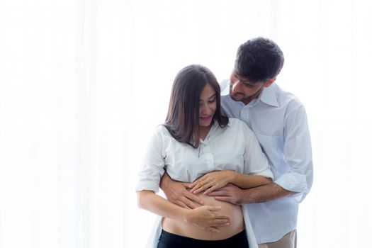 Pregnant Mother and father standing hugging holding belly, family concept.