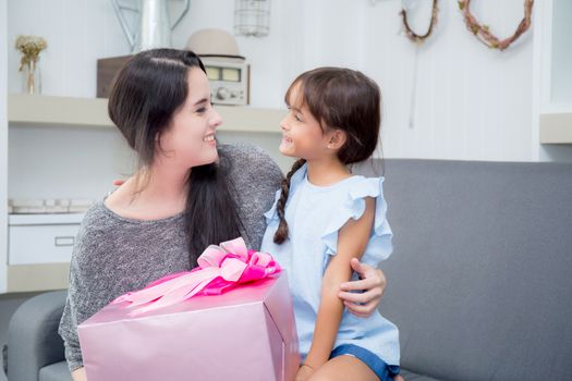 happy of mother and daughter asian with gift with pink ribbon and daughter kissing mother, Happy family concept. Happy mother's day.