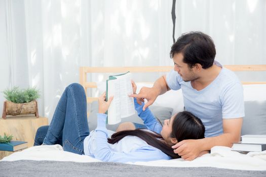 Couple reading a book together in bedroom on the morning with happiness.
