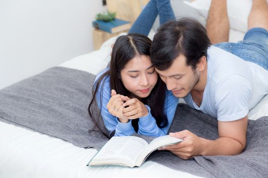 Couple reading a book together in bedroom on the morning with happiness.