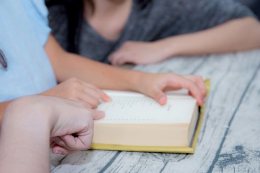 happy family mother and daughter teaching read a book at home.