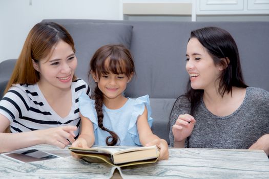 happy family mother, aunt, freind and daughter teaching read a book at home.