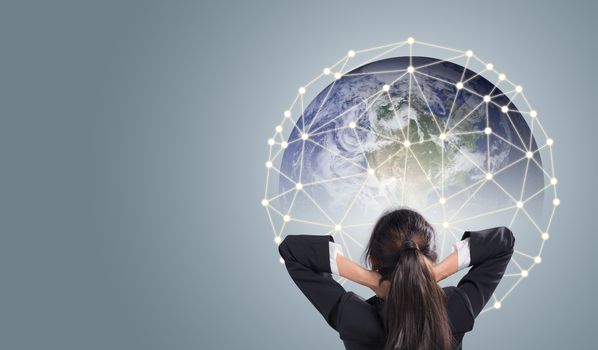 Rear view of businesswoman looking at network giant Earth communication network concept, Elements of this image furnished by NASA.