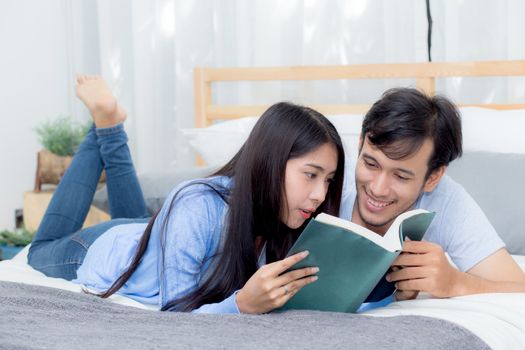 Couple reading a book together in bedroom on the morning with happiness.