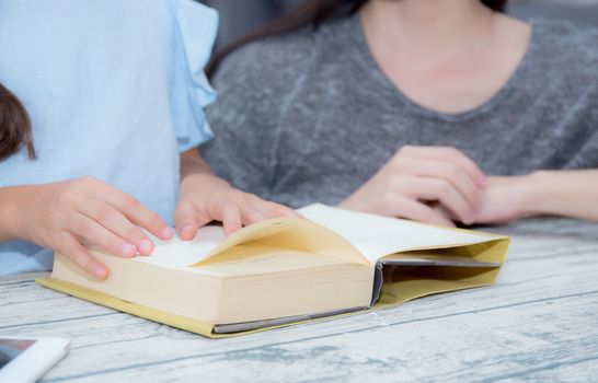 happy family mother and daughter teaching read a book at home.