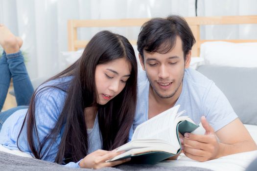 Couple reading a book together in bedroom on the morning with happiness.