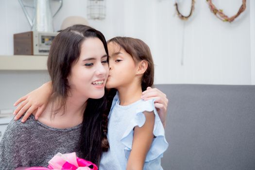 happy of mother and daughter asian with gift with pink ribbon and daughter kissing mother, Happy family concept. Happy mother's day.