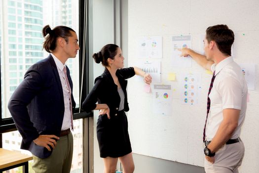 three business people in modern office looking report and analyzing with talking in meeting room.