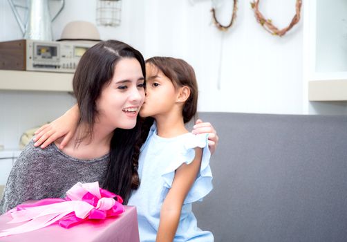 happy of mother and daughter asian with gift with pink ribbon and daughter kissing mother, Happy family concept. Happy mother's day.