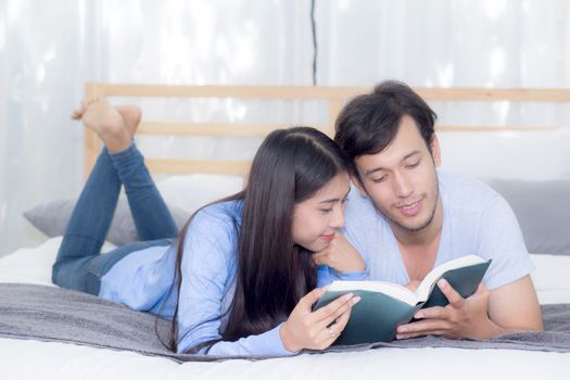 Couple reading a book together in bedroom on the morning with happiness.