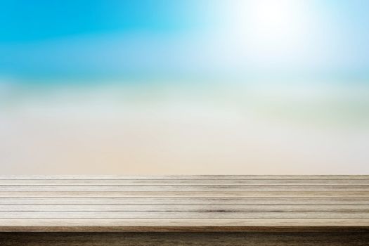 Wood table top on blurred beach background, summer concept - can be used for display your products.