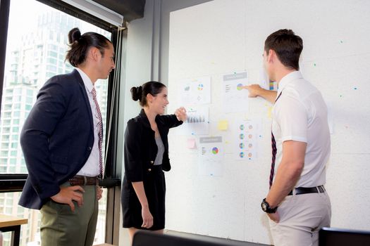 three business people in modern office looking report and analyzing with talking in meeting room.