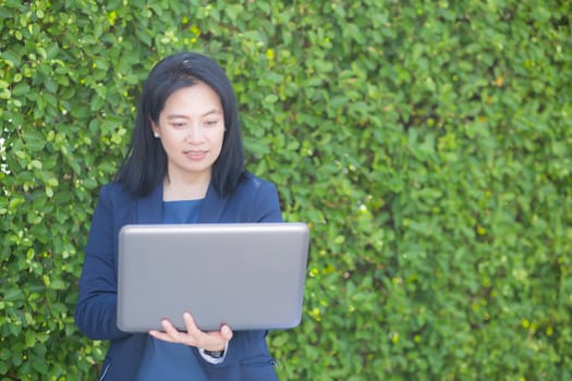 Asian businesswoman working with computer notebook in the outdoors.