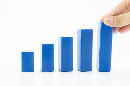 Businessman building a growing financial graph using wood toy, finance successful business concept