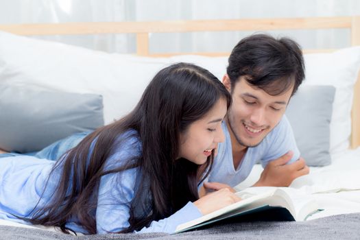 Couple reading a book together in bedroom on the morning with happiness.