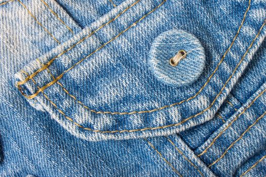 Smart jeans button in classic and pale color. Blue jeans fabric pocket.