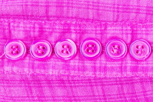 Purple button on scott fabric texture. Button of violet apparel background.