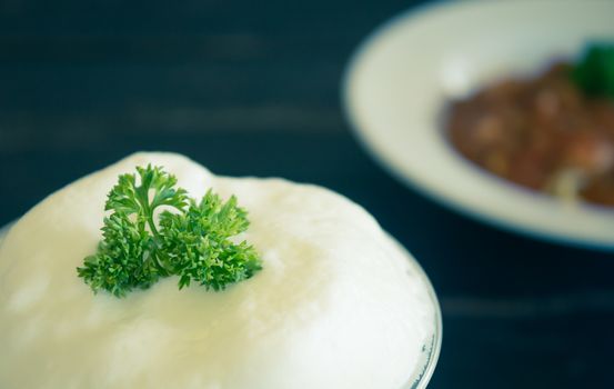 Milk froth and Parsley on Black Wood Table. Milk froth in plastic glass. Milk froth for food and drink category