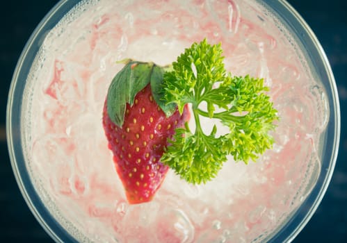 Red Italian Soda Cold Beverage and Strawberry Fruit and Parsley. Red Italian Soda Cold Beverage with strawberry fruit and ice in glass on wood table for food 
and drink category