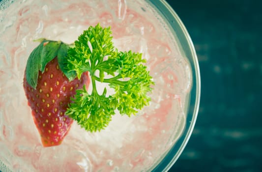 Red Italian Soda Cold Beverage and Strawberry Fruit and Parsley. Red Italian Soda Cold Beverage with strawberry fruit and ice in glass on wood table for food 
and drink category