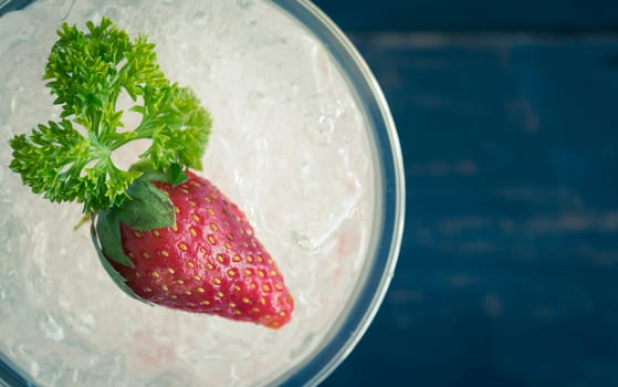 Red Italian Soda Cold Beverage and Strawberry Fruit and Parsley. Red Italian Soda Cold Beverage with strawberry fruit and ice in glass on wood table for food 
and drink category