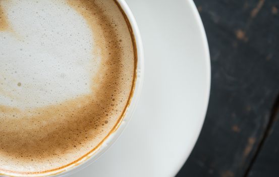 Flatlay Half Heart Shape Froth Milk Latte Art in White Coffee Cup on Black Wood Table. Heart shape froth milk Latte art hot beverage for coffee lover