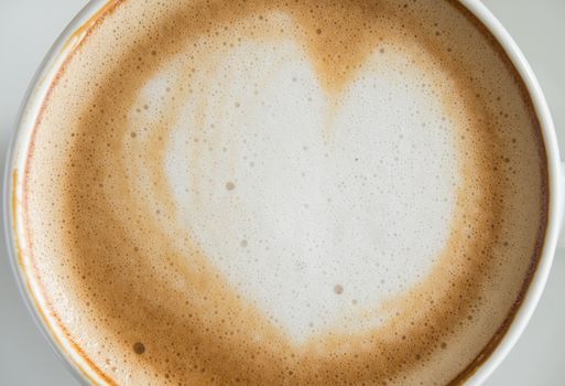 Flatlay Heart Shape Froth Milk Latte Art in White Coffee Cup Close Up on Black Wood Table. Heart shape froth milk Latte art hot beverage for coffee lover