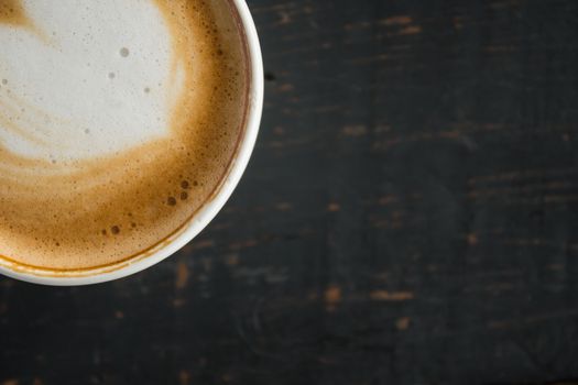 Flatlay Corner Heart Shape Froth Milk Latte Art in White Coffee Cup on Black Wood Table. Heart shape froth milk Latte art hot beverage for coffee lover