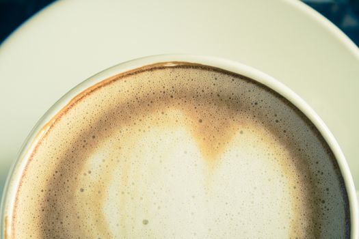 Vintage Flatlay Half Bottom Close Up Heart Shape Froth Milk Latte Art in White Coffee Cup on Black Wood Table. Heart shape froth milk Latte art hot beverage for coffee lover