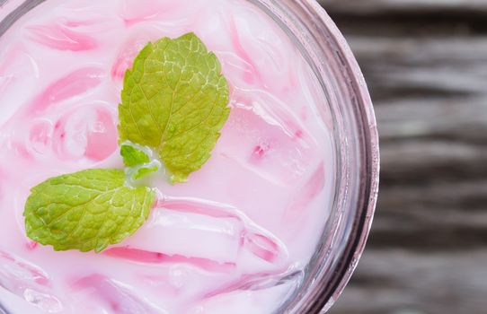 Pink Cold Milk Beverage or Cold Drinks and Peppermint Flatlay Left Frame. Pink cold drinks and ice on wood table for drink