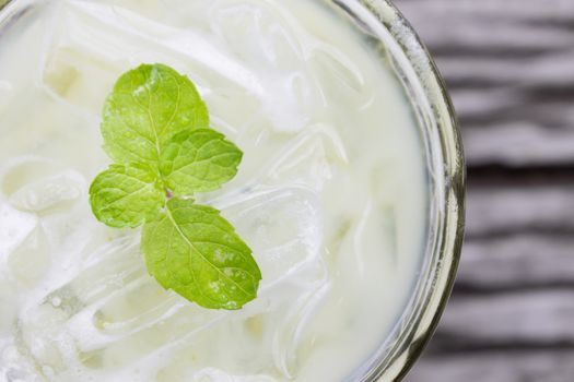 Cold Green Tea Milk Beverage or Cold Drinks Flatlay Left Frame. Green cold drinks and ice on wood table for drink