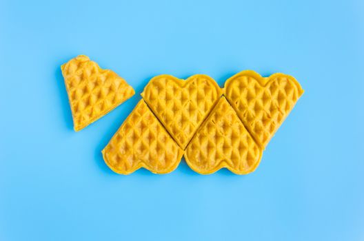 5 Pieces in Row Waffle on Blue Pastel Background Minimalist Style. Heart shape waffle dessert in minimalist style for food and dessert category