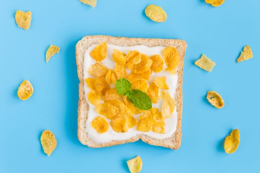 Cornflakes on Yogurt with Bread with Peppermint and Cornflakes on Blue Pastel Background Flatlay. Cereal Breakfast bread healthy clean food for food and dessert category