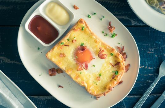 Egg Yolk Bacon Ham Cheese Toast and Coriander. Breakfast egg yolk bacon ham cheese with bread toast with coriander on top for food and drink category